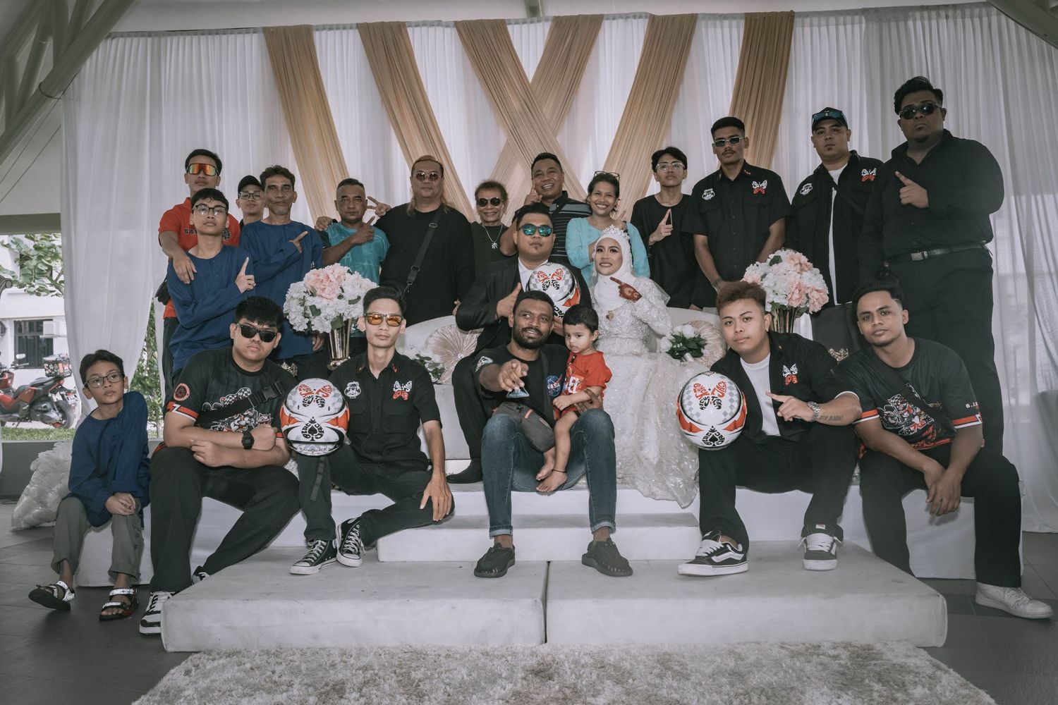 Group photo of guests in casual attire against white backdrop with geometric pattern.