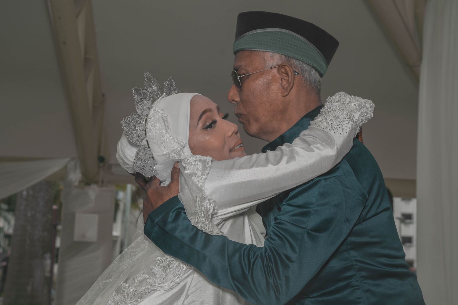 Emotional embrace between family members during traditional Muslim wedding ceremony.