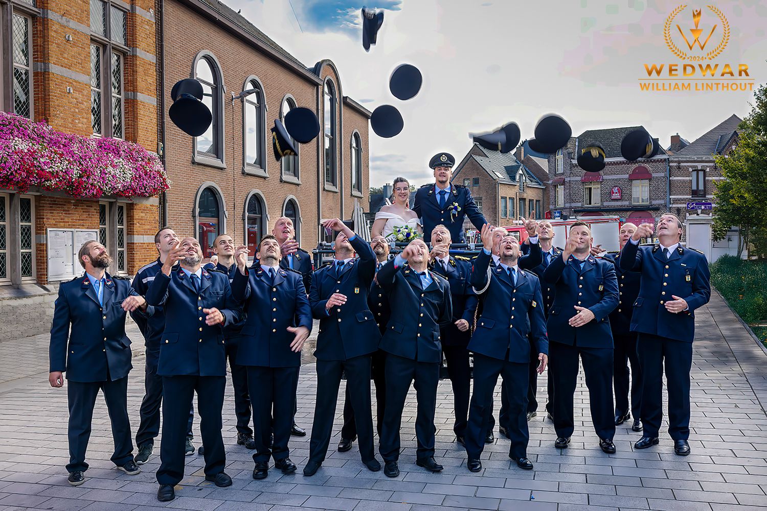 Group of people in blue uniforms tossing caps in the air during a celebration.