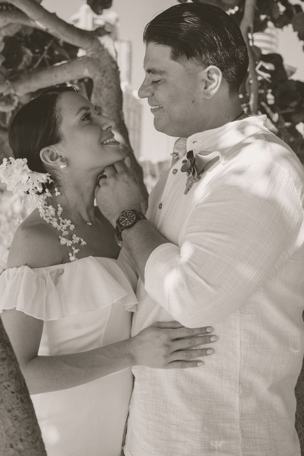 A romantic black and white portrait of newlyweds sharing an intimate moment.