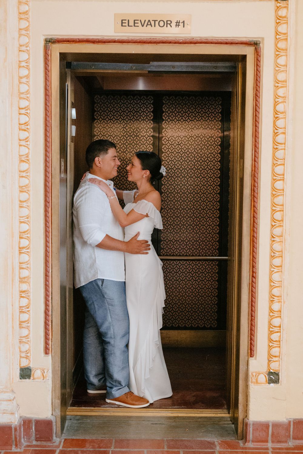 A couple shares a romantic moment in Elevator #1 with decorated interior pattern walls.