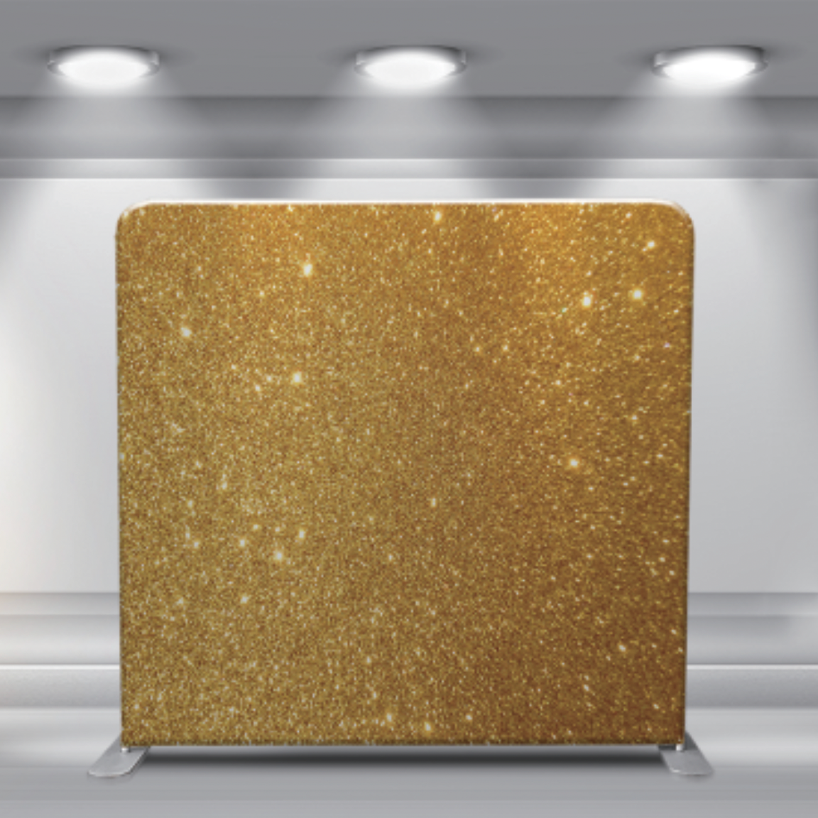 Gold glitter backdrop display panel with overhead lighting and metallic shimmer effect.