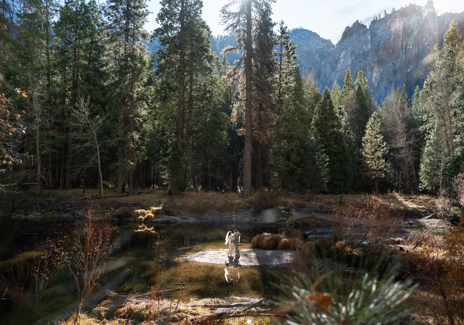 A newly wed couple dancing on a sand bar in the river at Yosemite