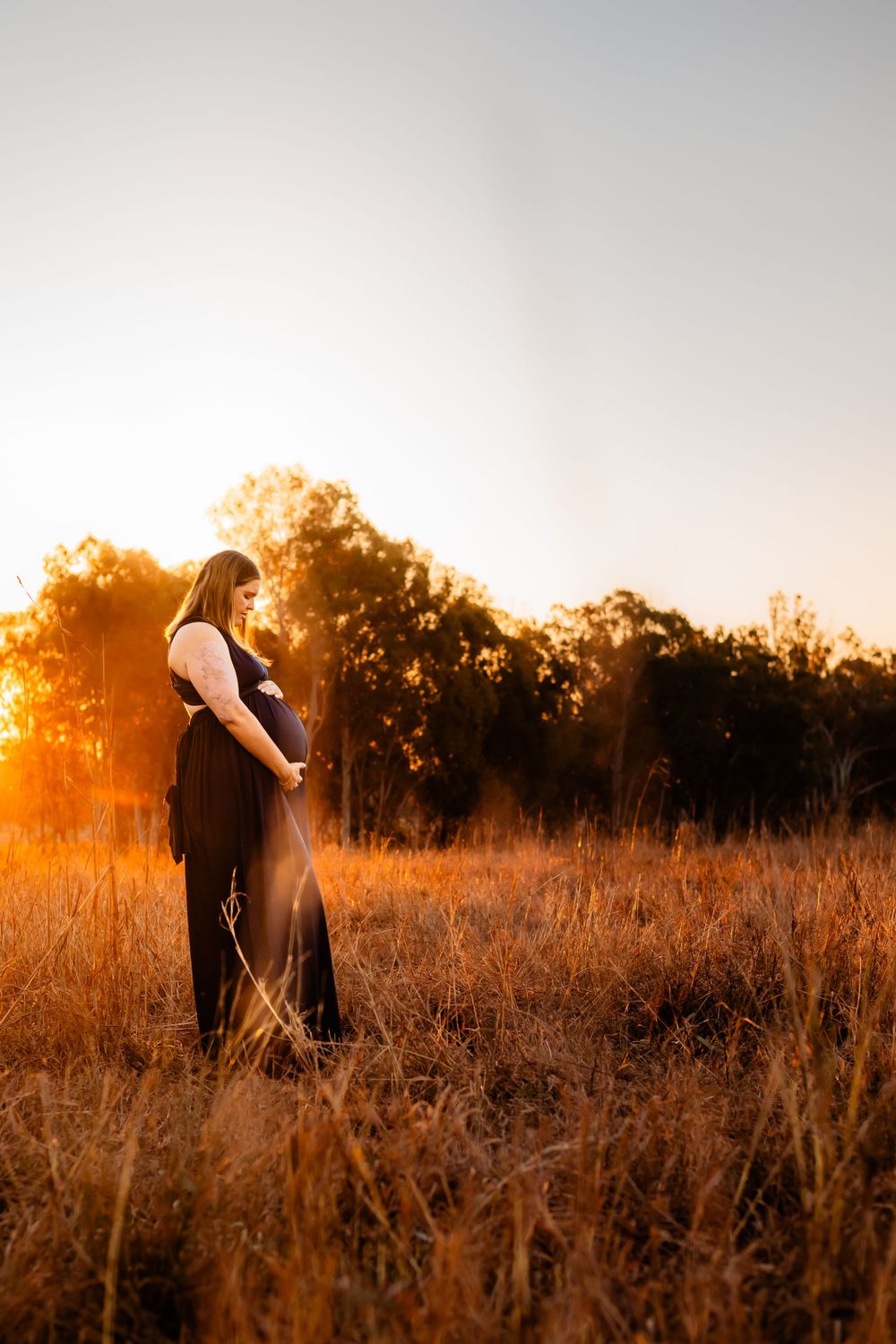 A silhouette against golden sunset light in a field of tall grass.
