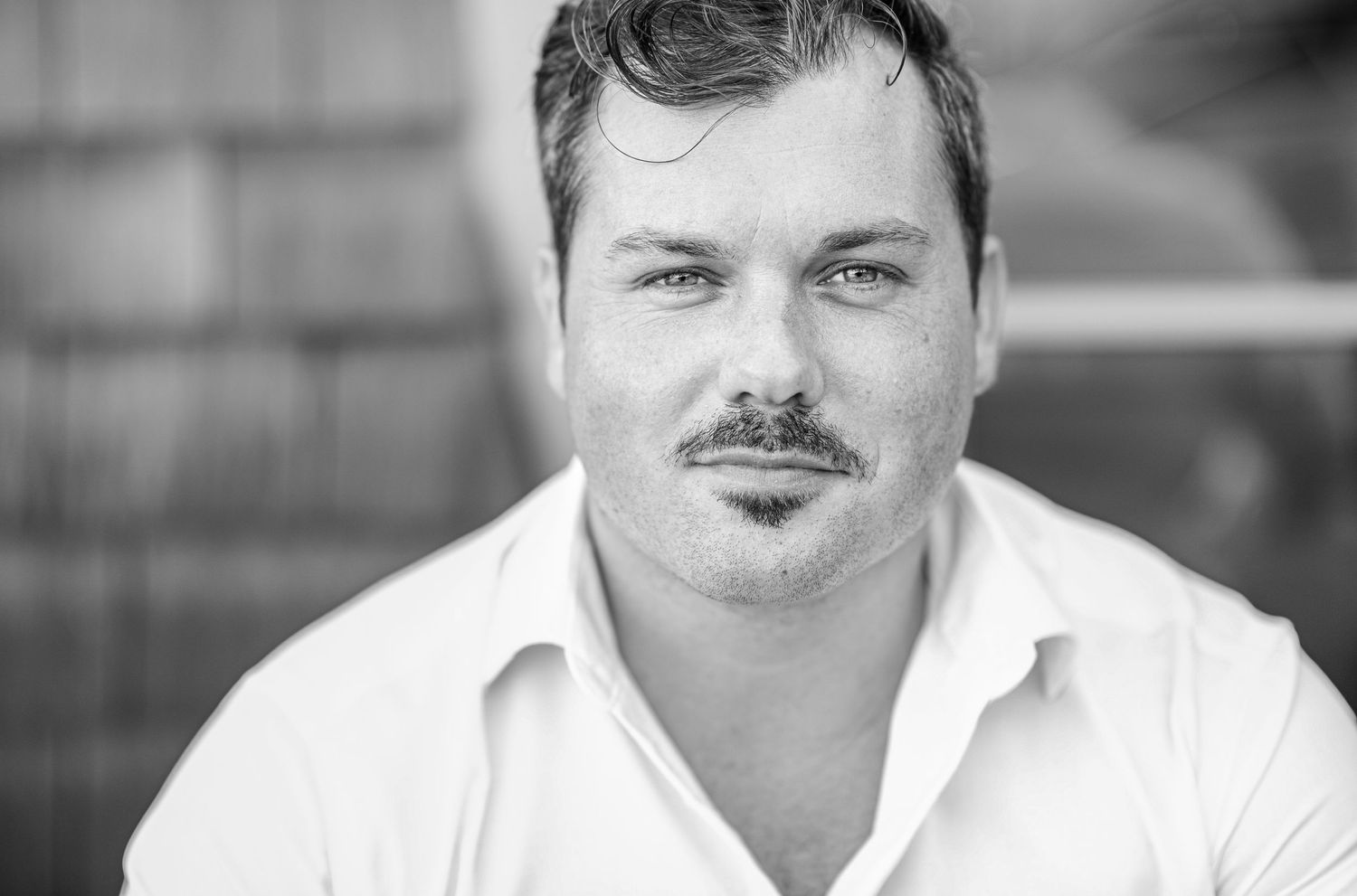 Black and white outdoor portrait in white collared shirt.