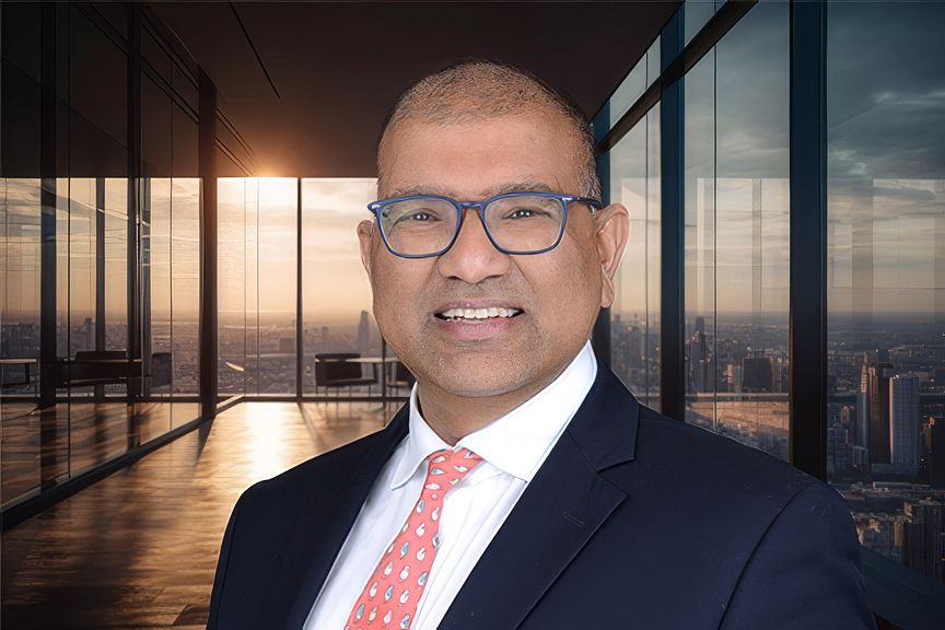 Corporate portrait with city skyline background wearing business suit and red tie.