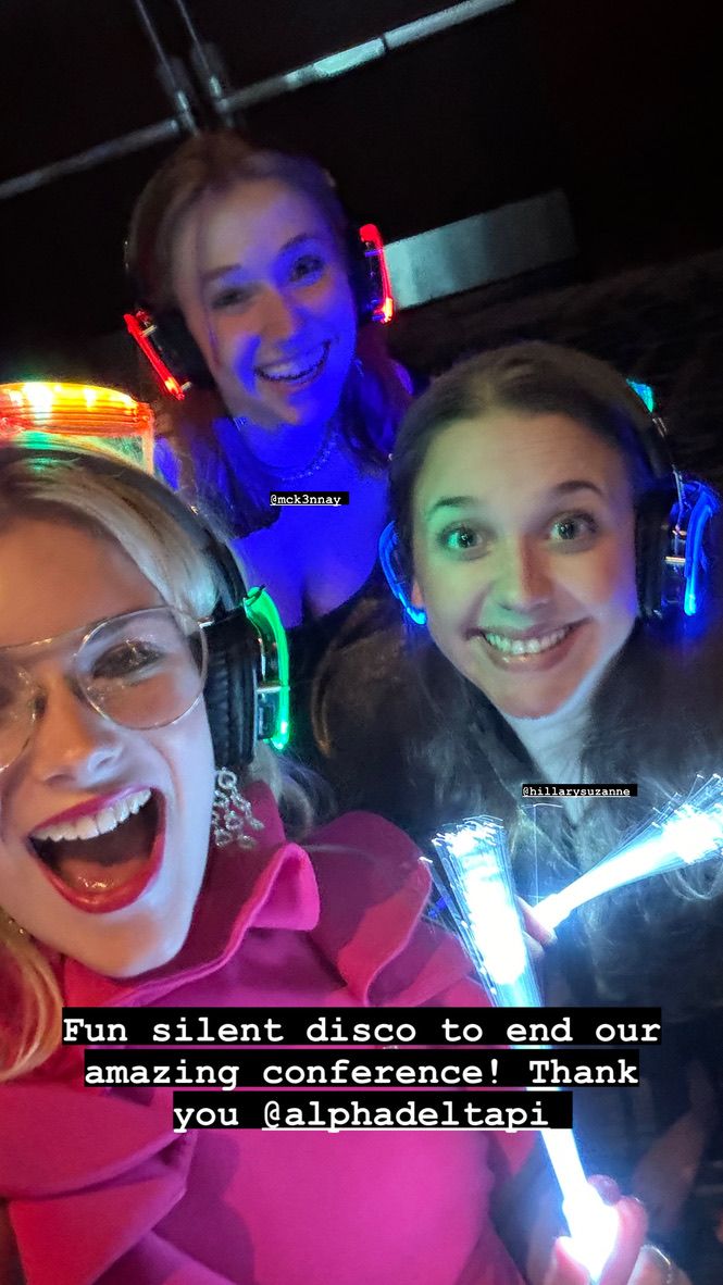People enjoying a silent disco party with colorful neon lights and headphones in a dark venue.