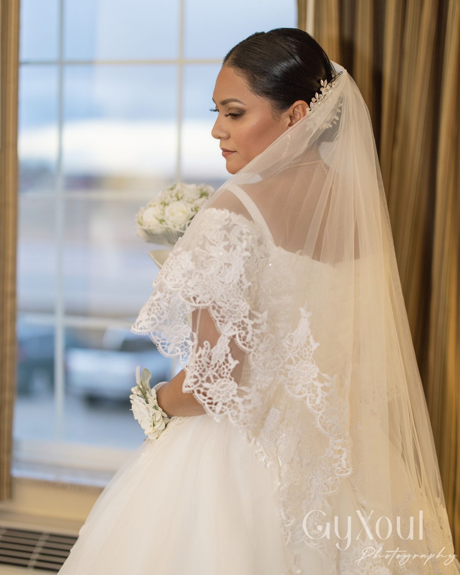 Couple in formal wedding attire embracing and dancing together in an elegant setting.