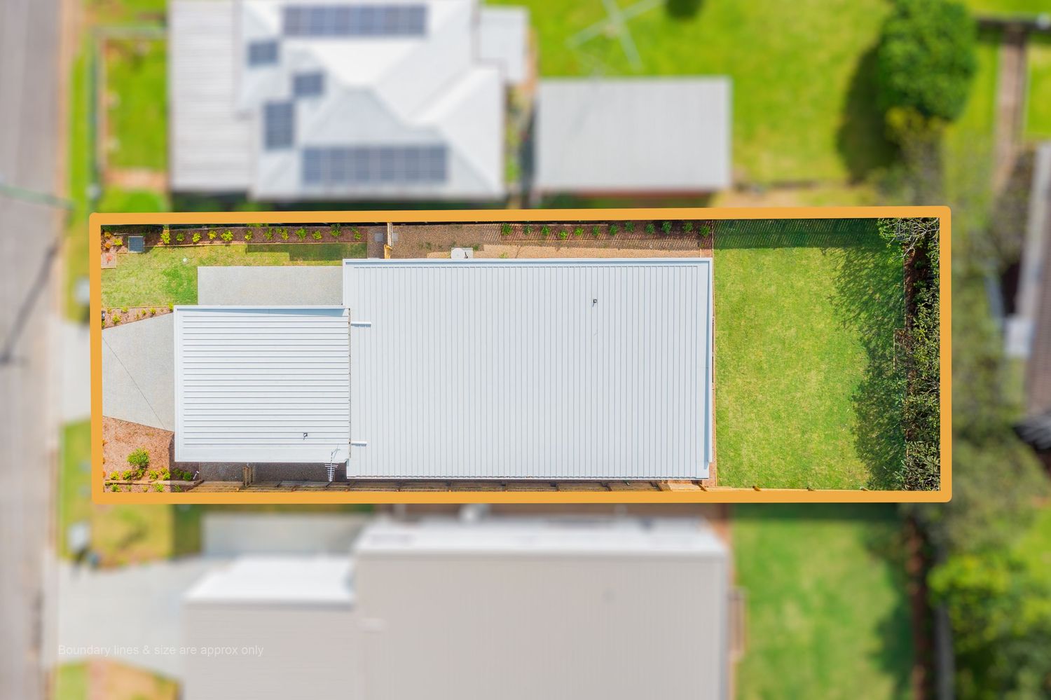 Overhead aerial view of a rectangular residential property with a metal roof home and large backyard, outlined in orange.