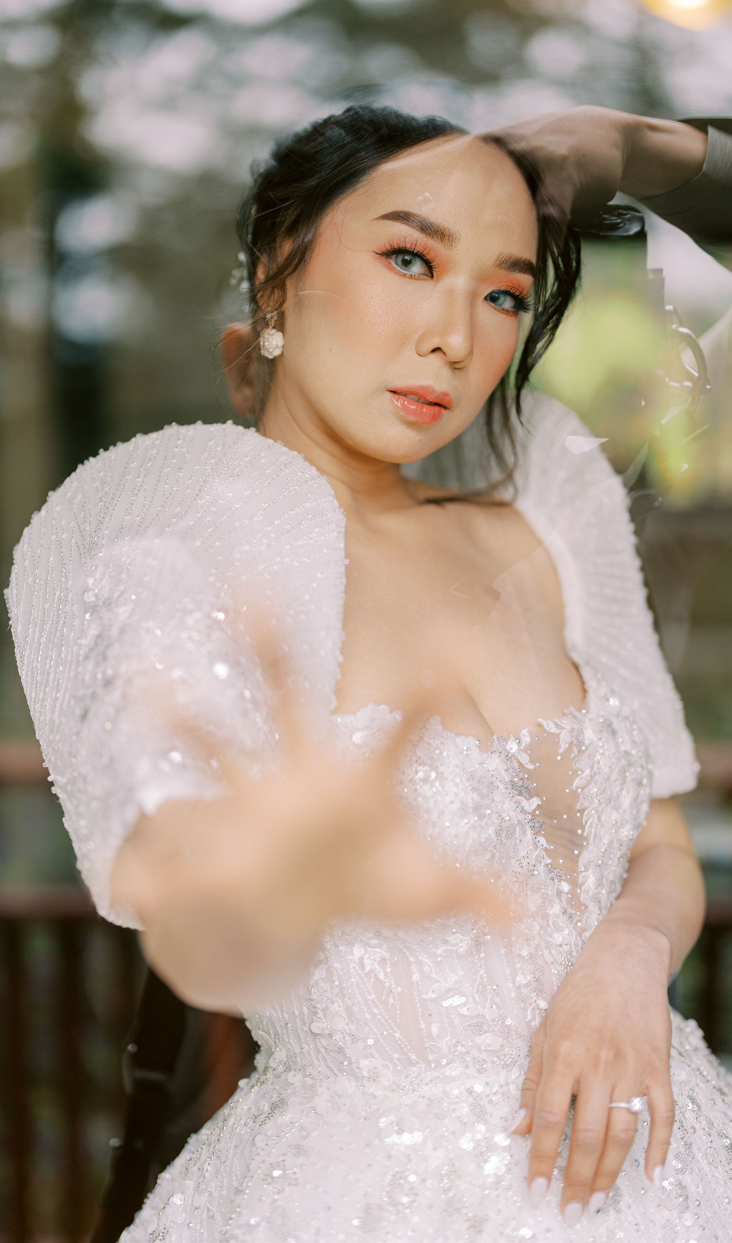 Close-up bridal portrait featuring delicate lace details and pearl earrings.