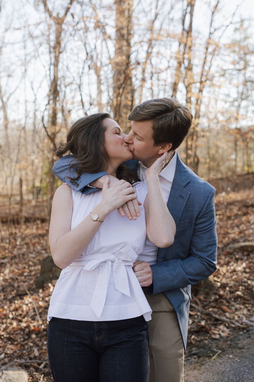 A couple shares intimate moments during an autumn photoshoot with fallen leaves in the background.