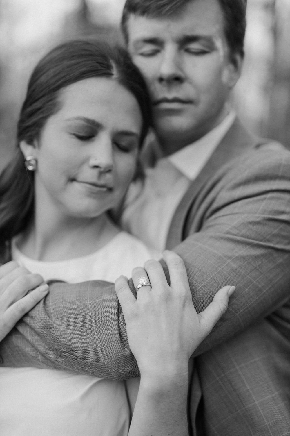 Black and white close-up shots of a couple showing affection and engagement ring details.