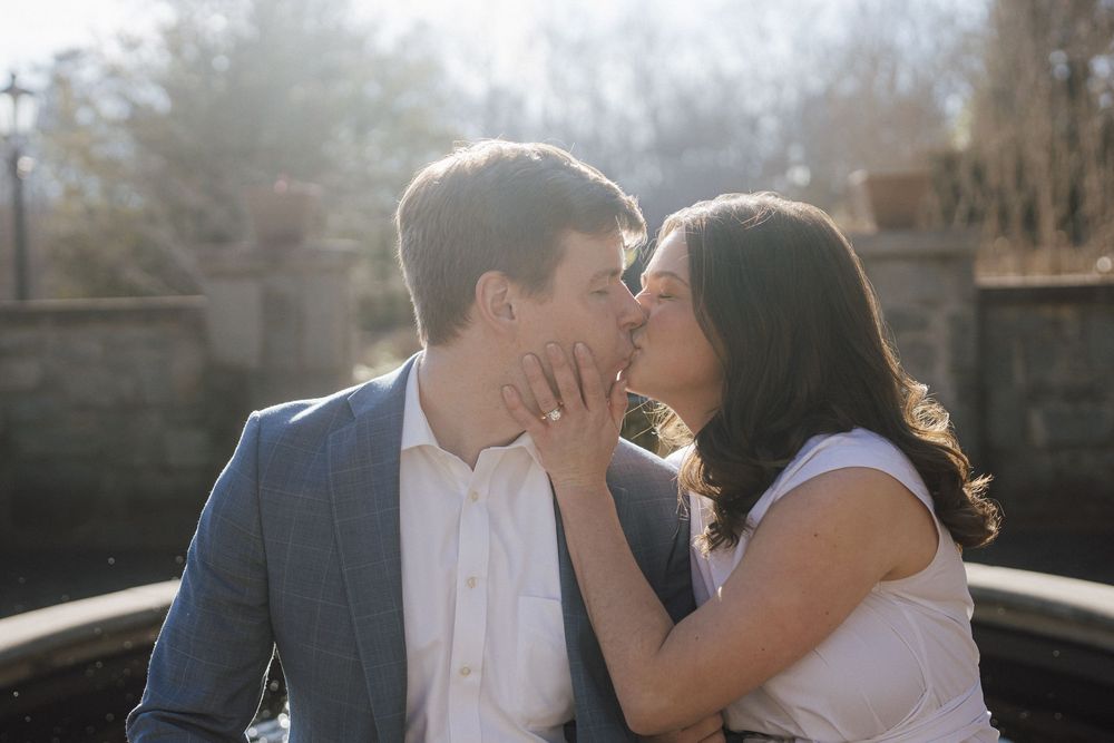 A couple embraces during a romantic photoshoot with natural backlighting.