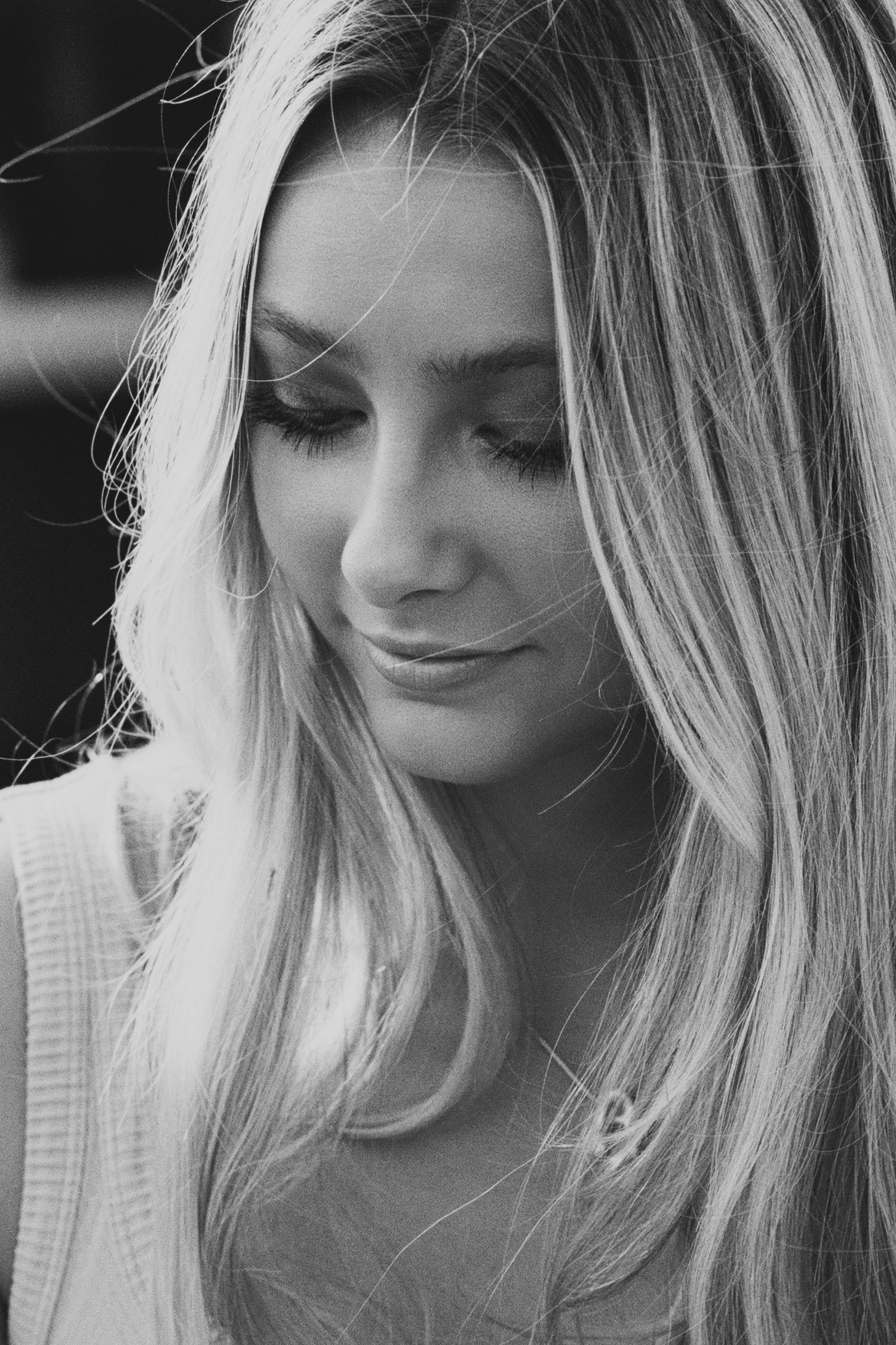Black and white portrait series showing downward glances and contemplative expressions with long blonde hair framing the face.