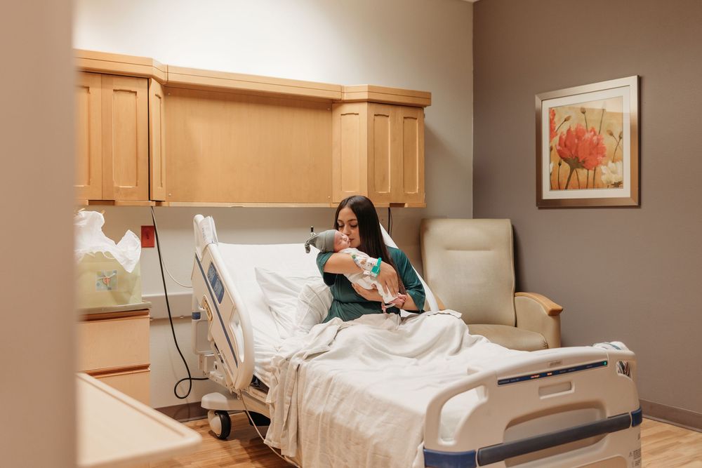 Mother holding her newborn baby during a Fresh 48 hospital session