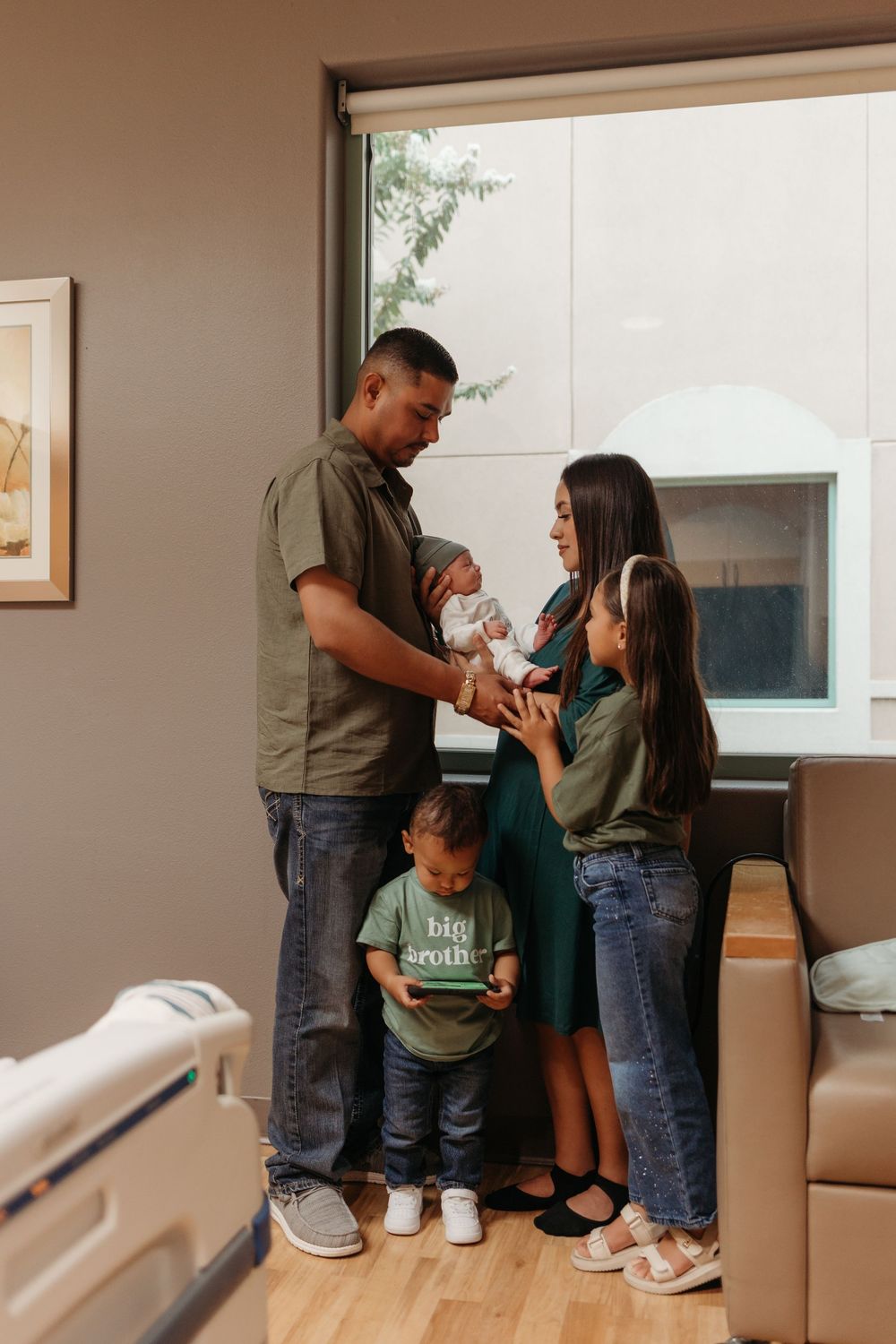 Mother and family holding her newborn baby during a Fresh 48 hospital session