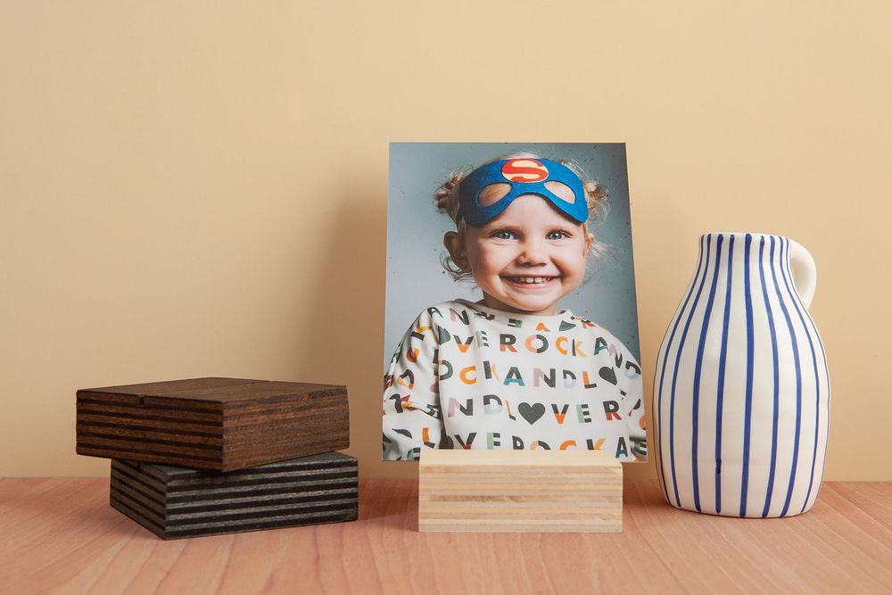 A collection of ceramic vases and decorative items arranged on a wooden surface against a beige wall.