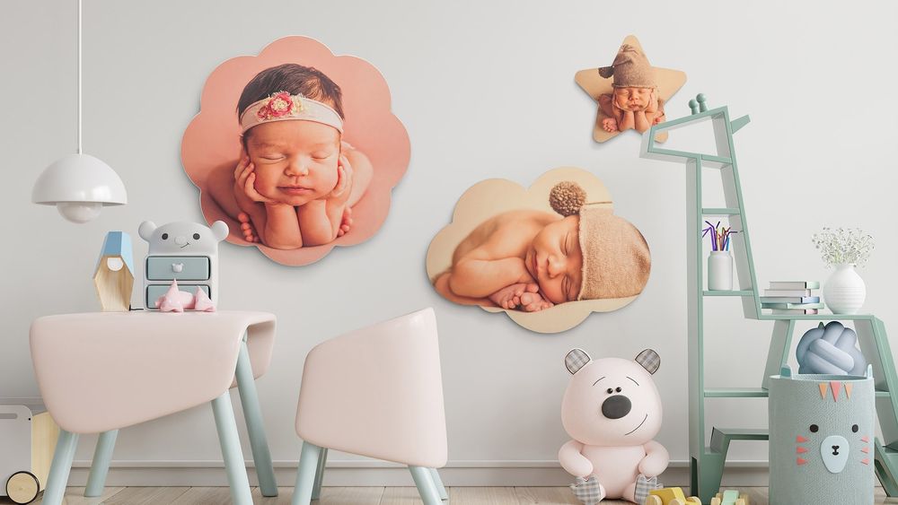 A sleeping newborn baby wrapped in soft fabric lies peacefully on a white surface with pastel decorations nearby.