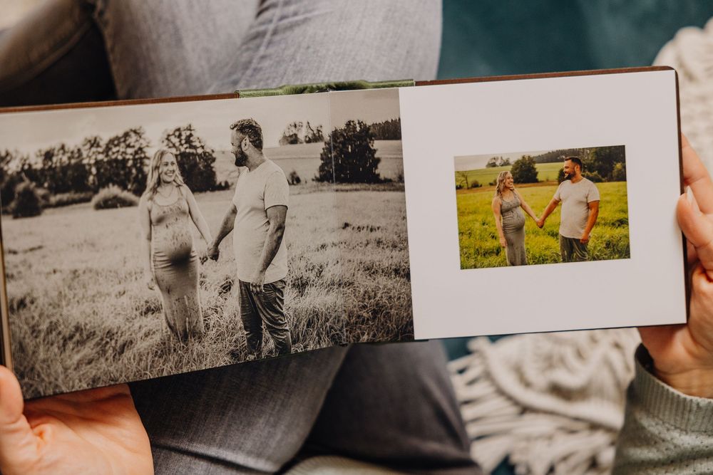 A collection of old black and white photographs being arranged and displayed on a wooden surface.