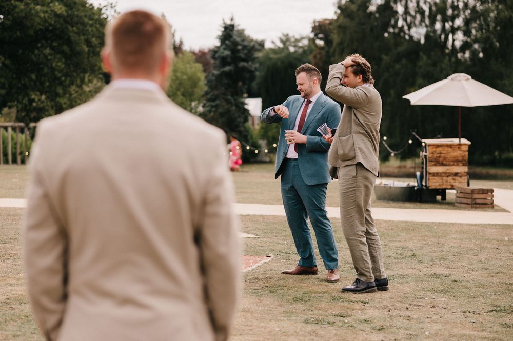 A group of people in formal attire dance and celebrate outdoors at a wedding reception.
