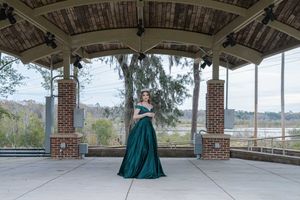Charleston prom photographer capturing high school senior portrait in green formal dress under pavilion