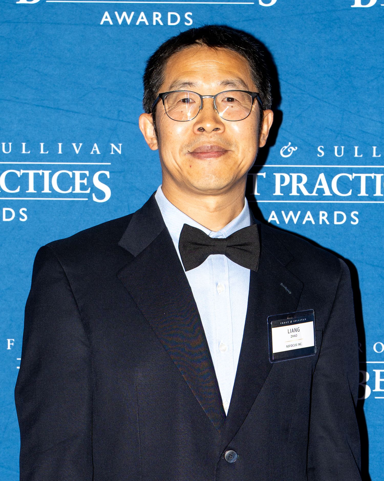 Attendees in formal attire pose at an awards ceremony with blue backdrop displaying Sullivan Awards text.