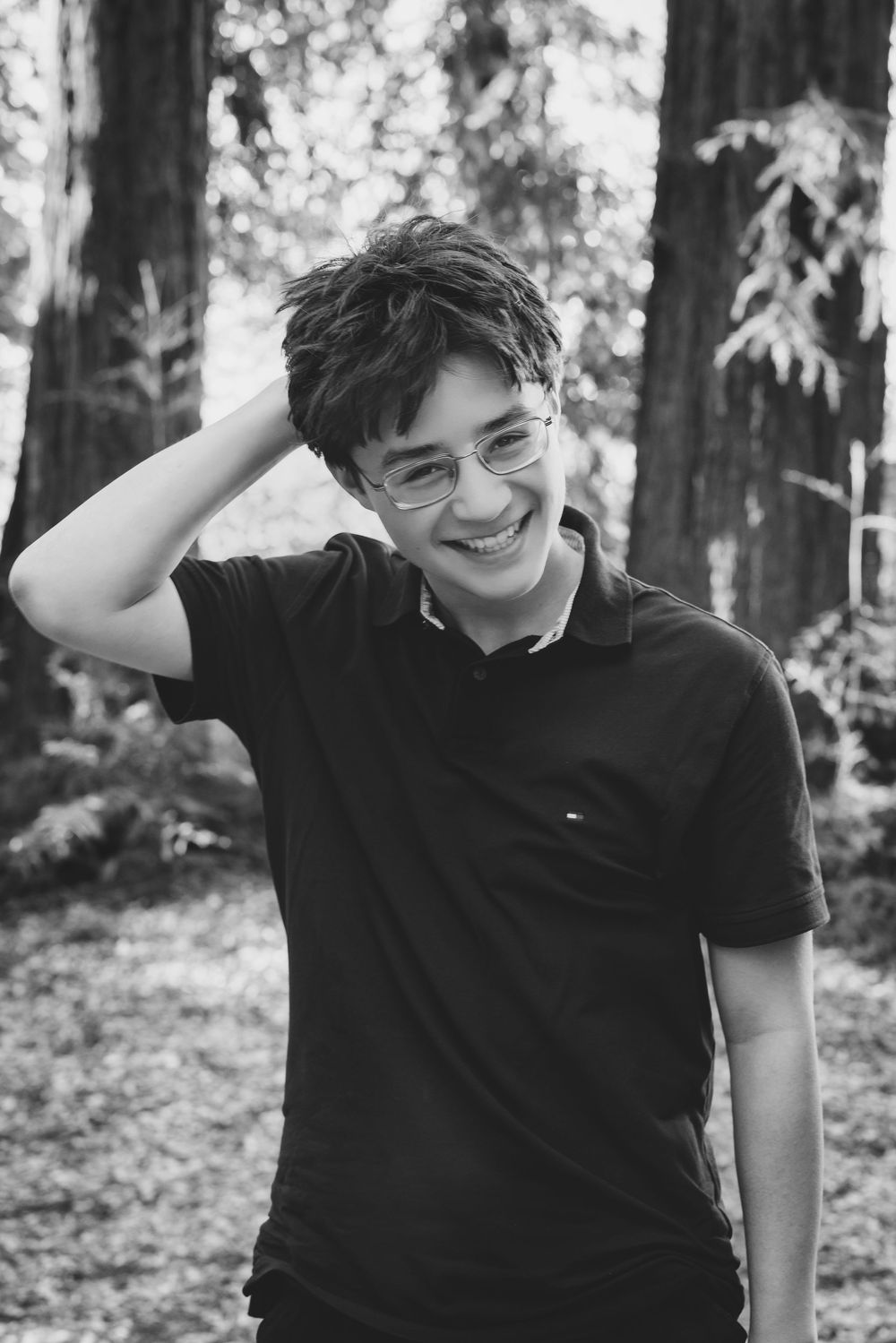 A series of black and white portraits showing joyful expressions against a wooded background.