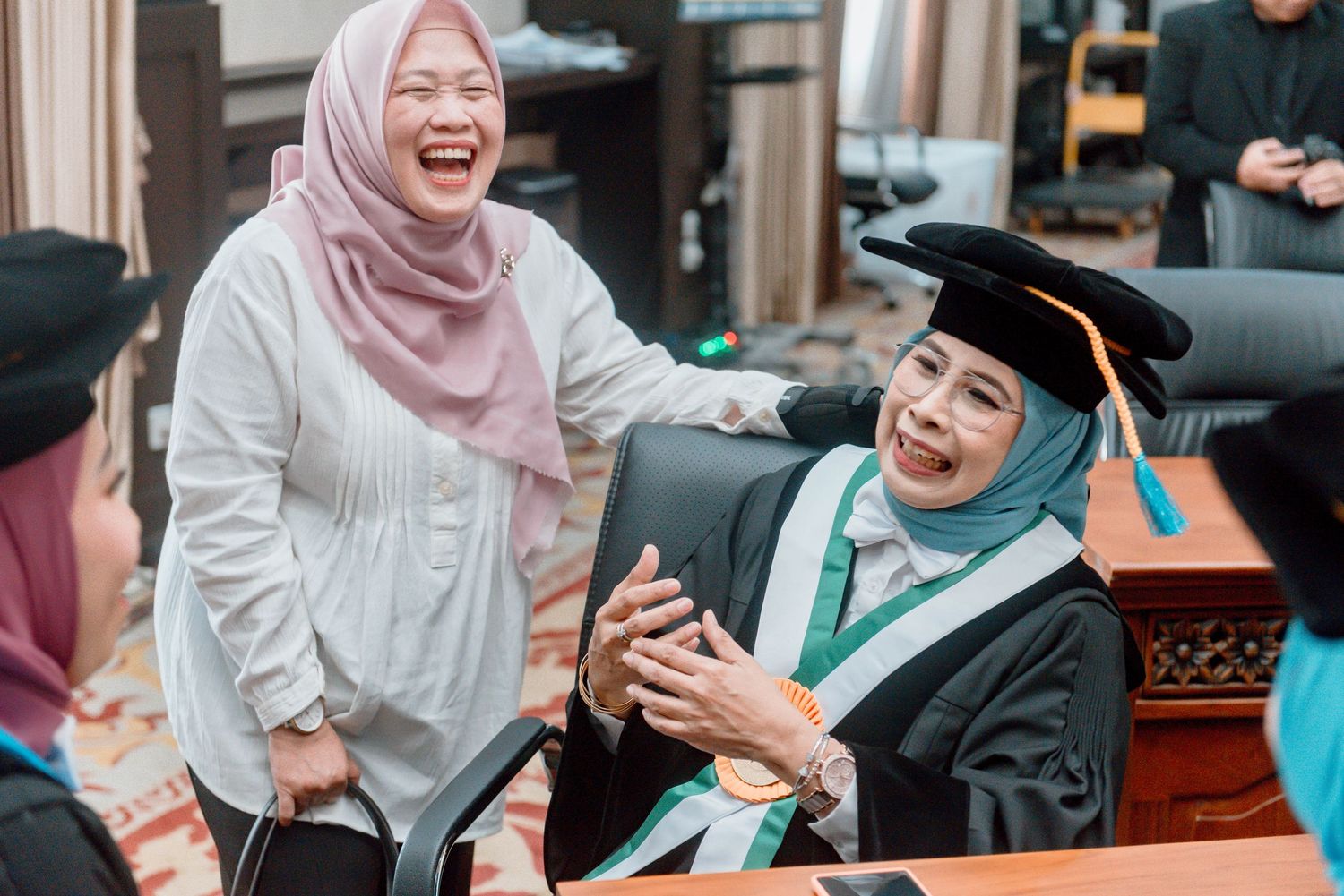 Students in graduation attire share joyful moments during a commencement ceremony celebration.