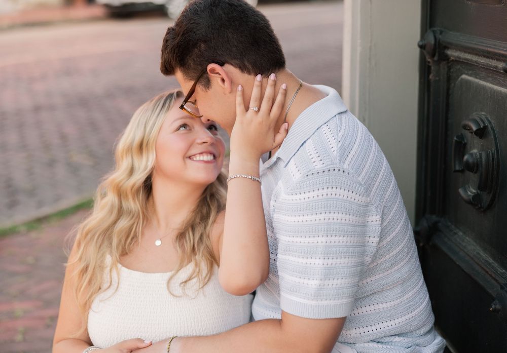 Romantic couple in white outfits share tender moments during outdoor engagement photo session. German Village Engagement session