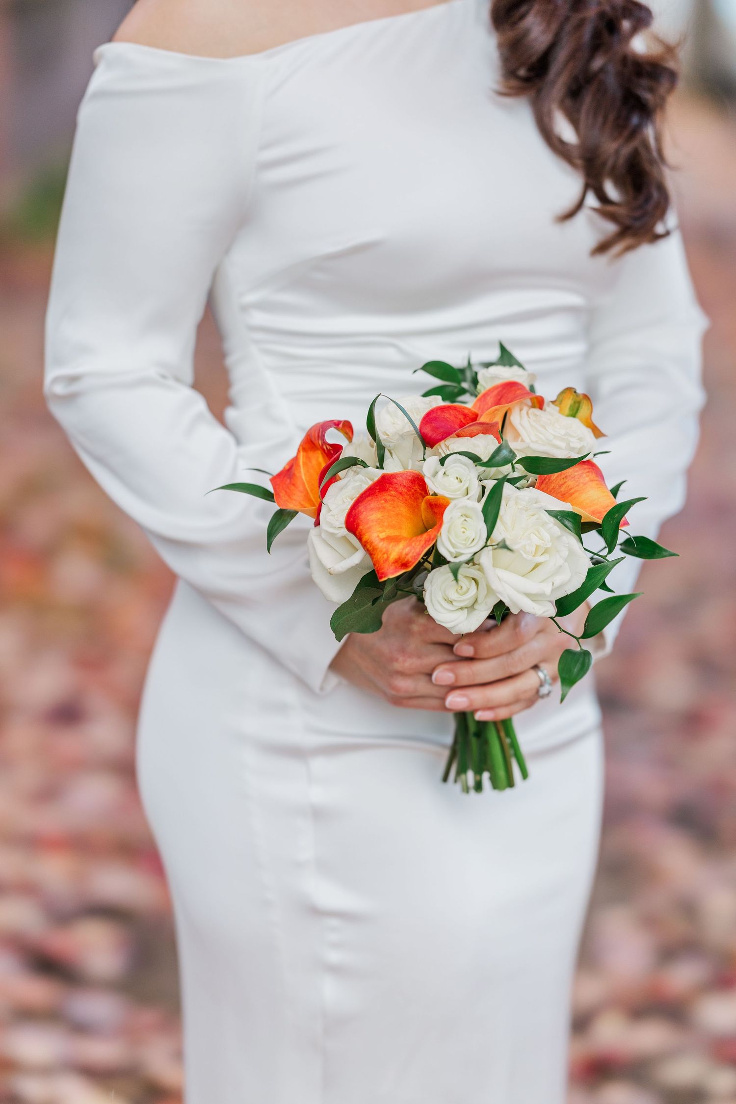 Close-up shots of a white wedding dress with a bouquet featuring orange and white roses with green foliage.