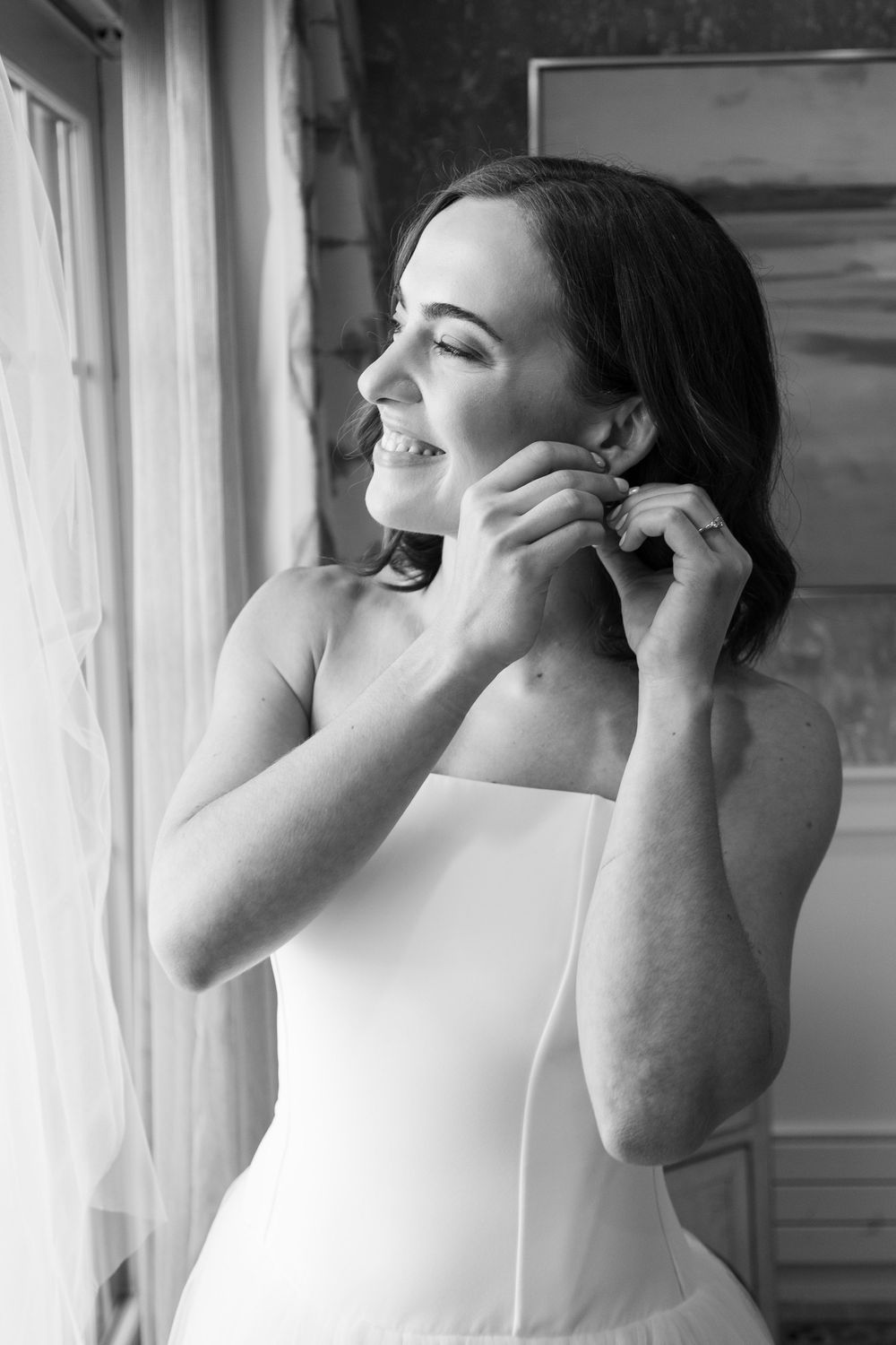 A black and white photo series showing someone putting on a face mask near a window.