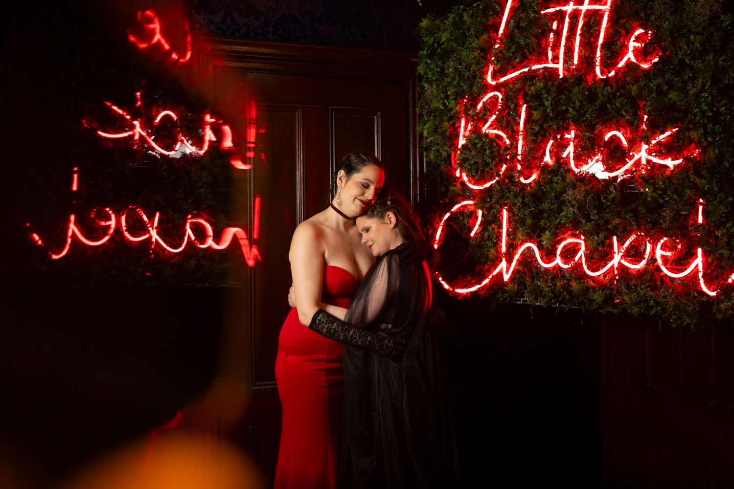 Little Black Chapel sign in red neon frames a queer couple who has just eloped in New England.