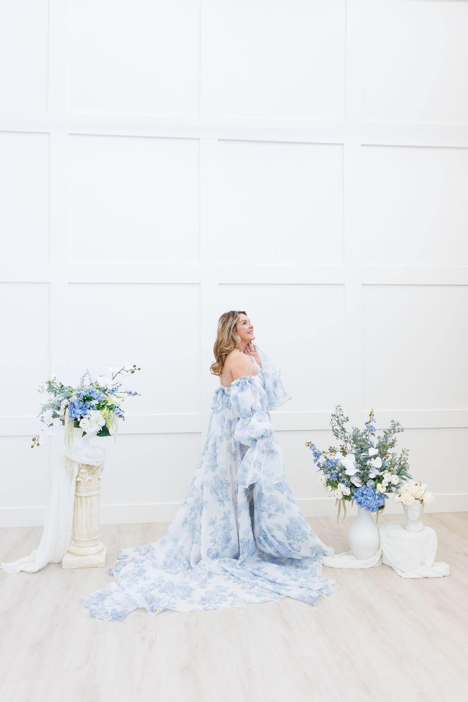 Ethereal bridal boudoir photo series in soft blue and white tones featuring flowing fabric and delicate floral arrangements.