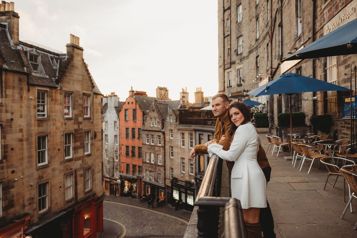 A cozy scene on Victoria Street in Edinburgh's Old Town with historic stone buildings and outdoor cafe seating.
