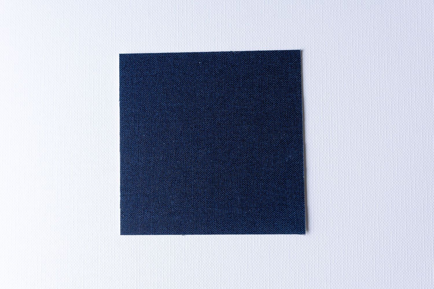 Several pieces of blue denim fabric samples arranged in a row against a light gray background.