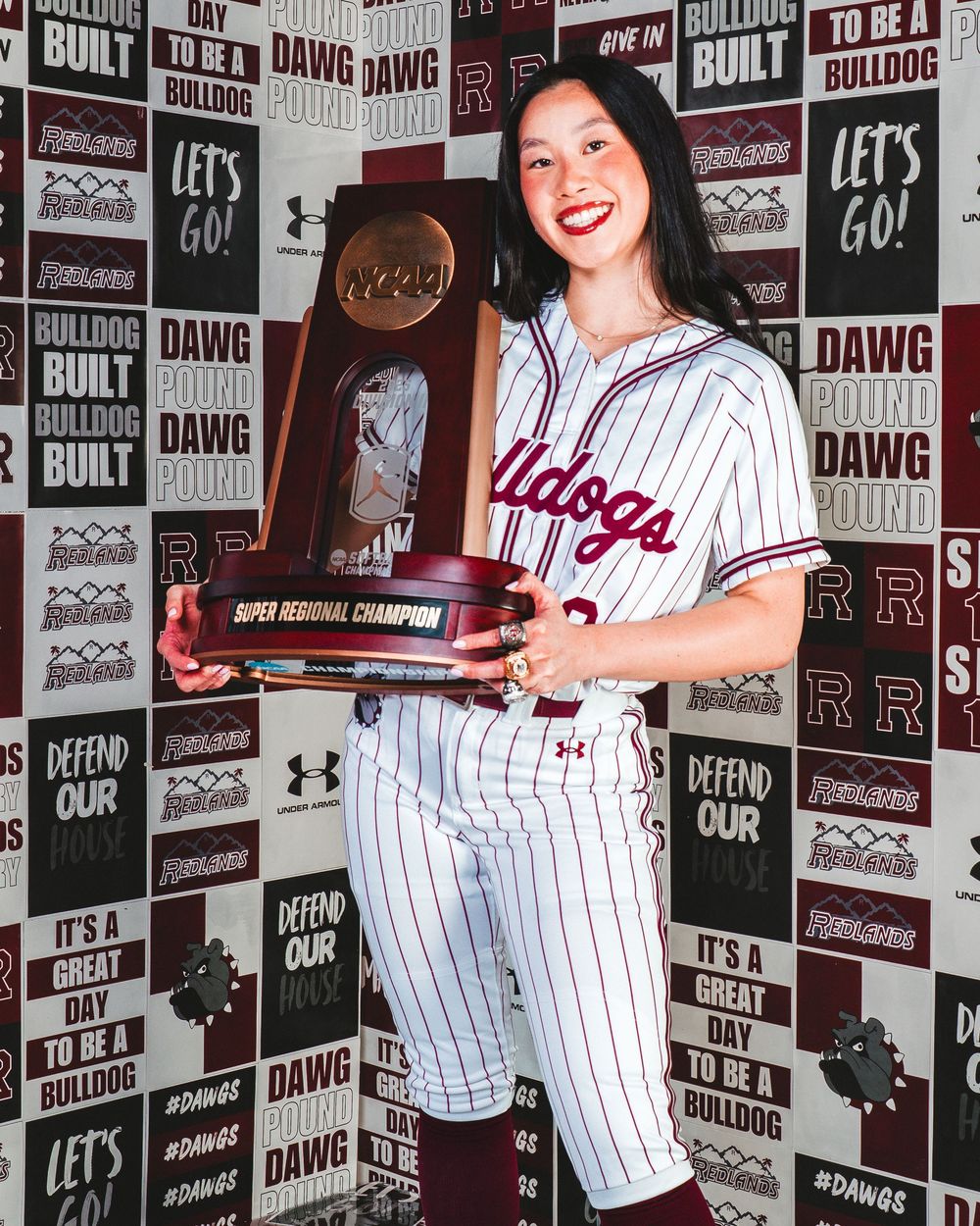 Baseball themed photo studio with pinstripe uniform against branded backdrop wall.