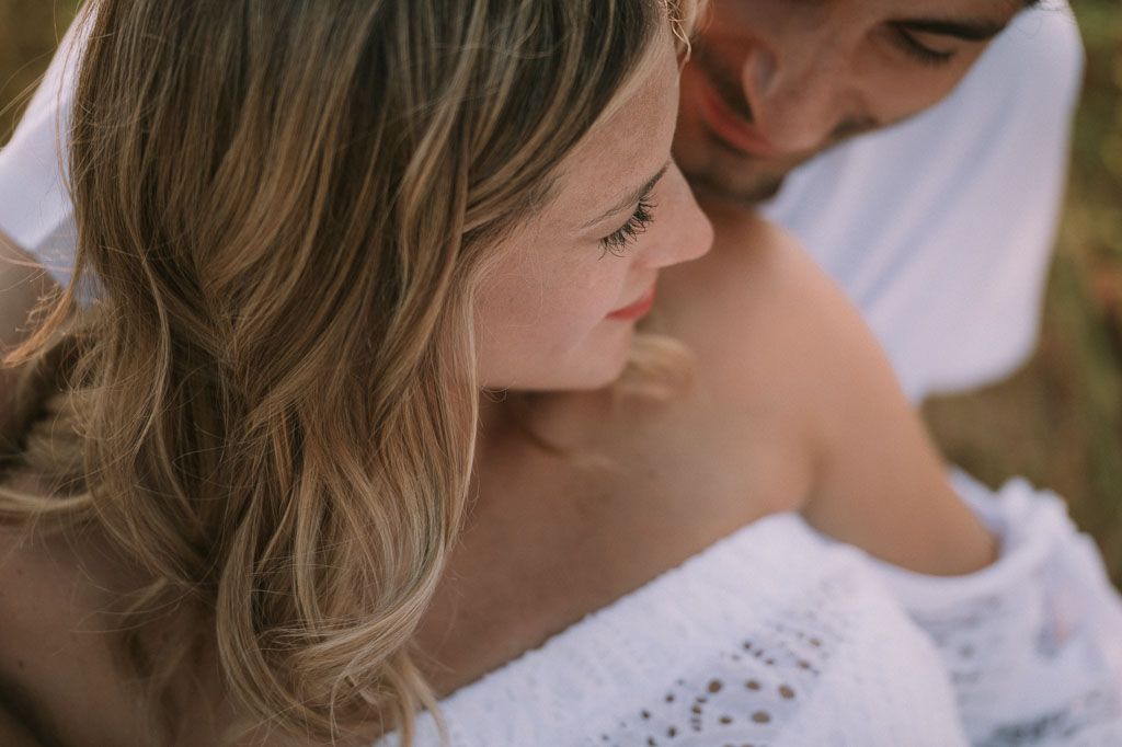 Close-up view of white lace dress details and soft hair styling.