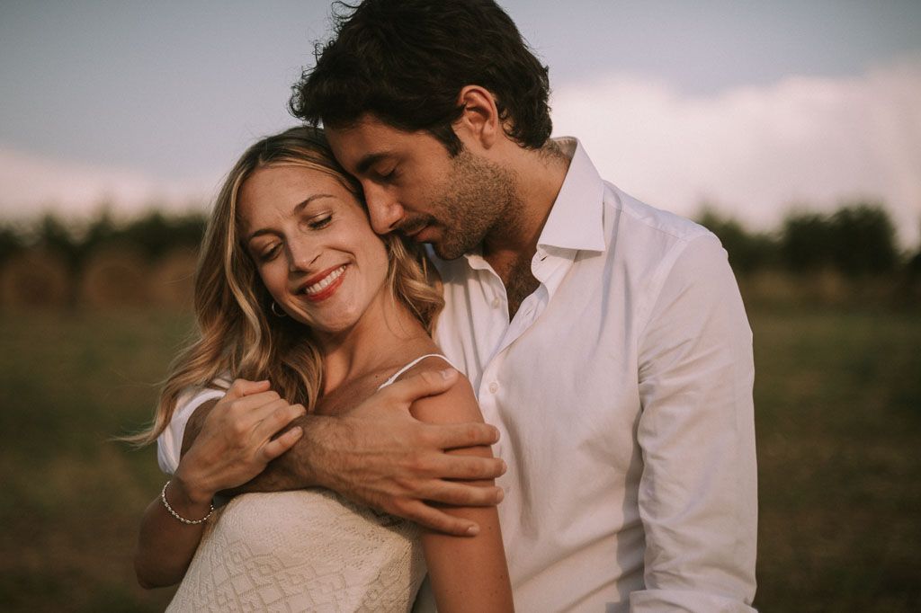 Romantic maternity portraits captured in natural outdoor setting during golden hour.
