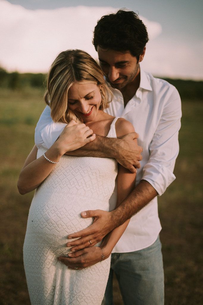 Emotional maternity photography session showing couple's tender moments outdoors.