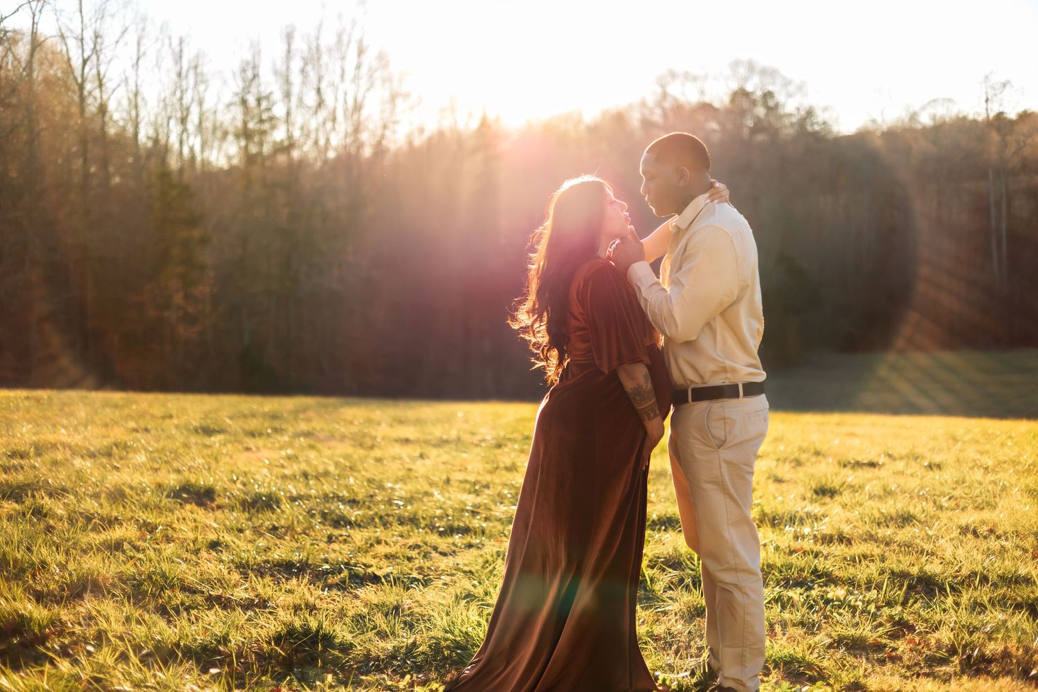 Maternity couple taking photos in sunset golden hour