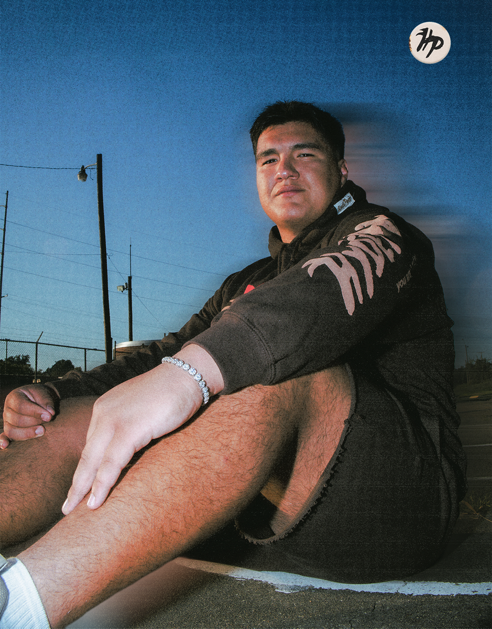Close-up shot of person resting on ground wearing dark clothing at sunset.