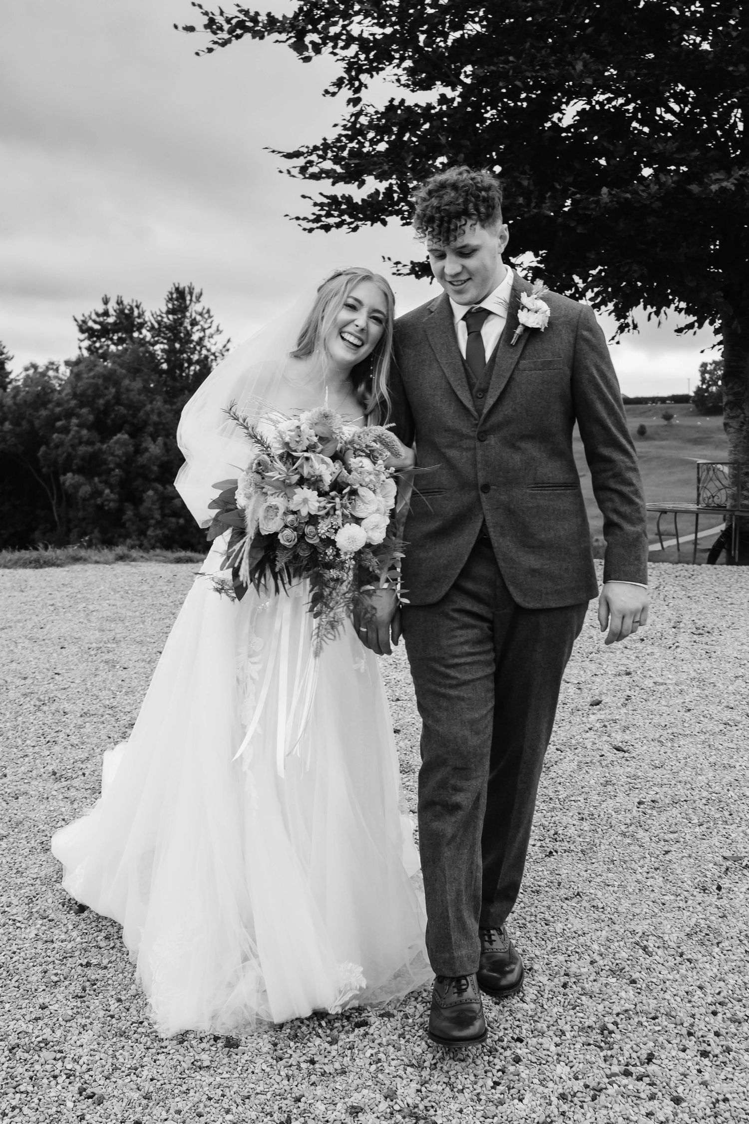 Cotswolds countryside wedding venue landscape Kingscote barn black and white image of couple
