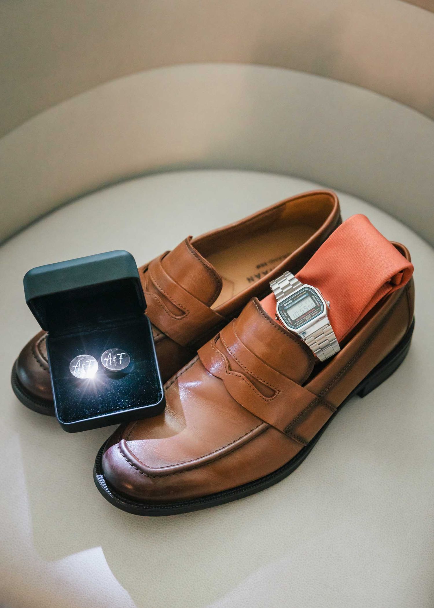 Groom details including brown wedding shoes, watch, tie, and monogram cufflinks during Boston wedding preparations