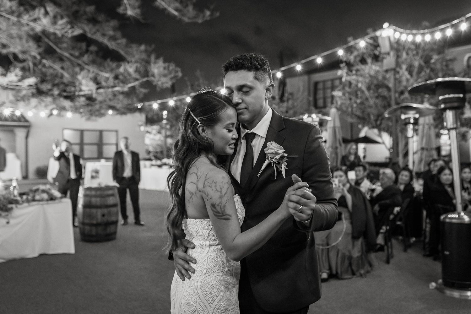 Couples dancing together at an outdoor evening wedding reception with string lights overhead at Stone Brewing in San Diego.
