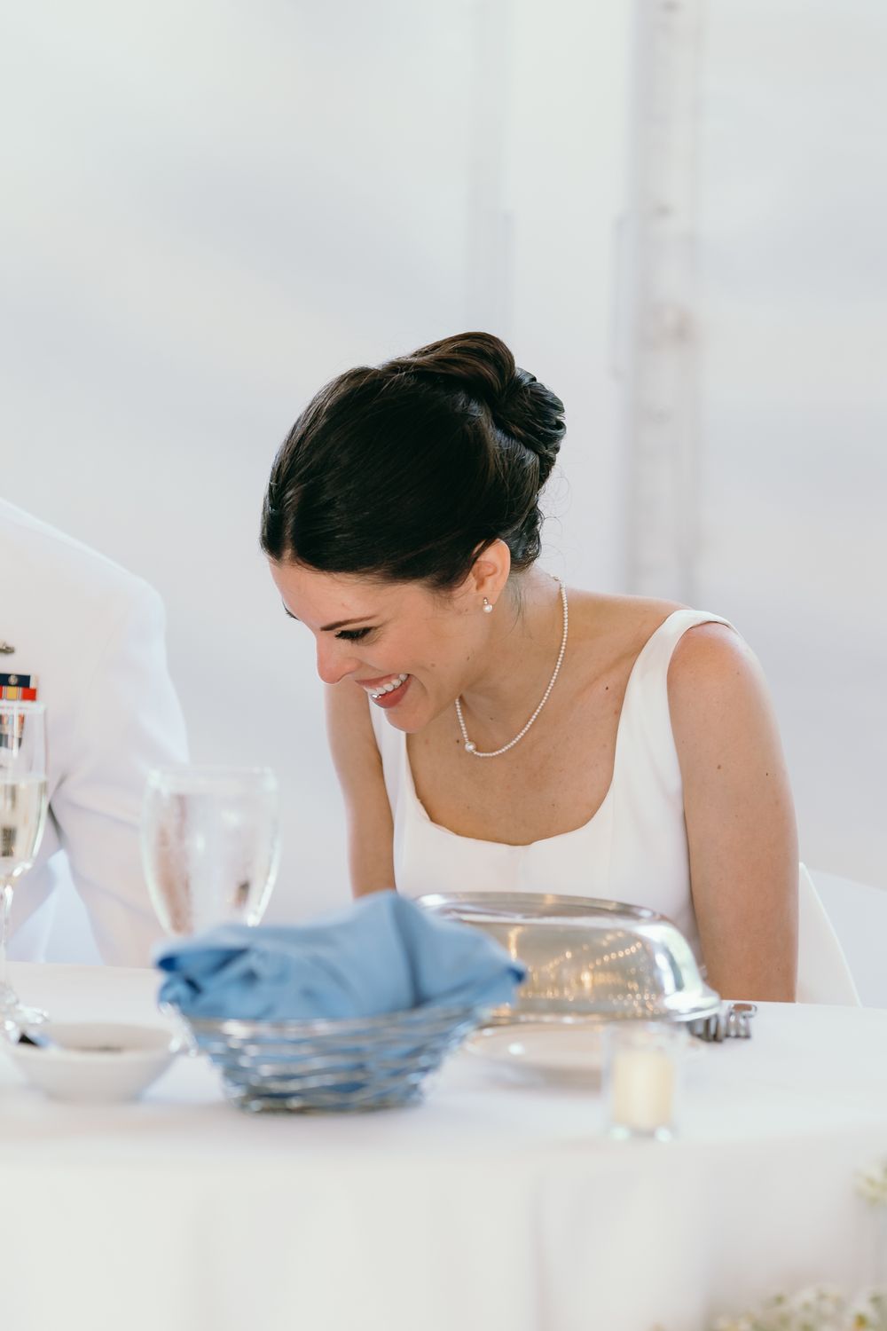 Candid moments captured at an elegant white-themed wedding reception table.