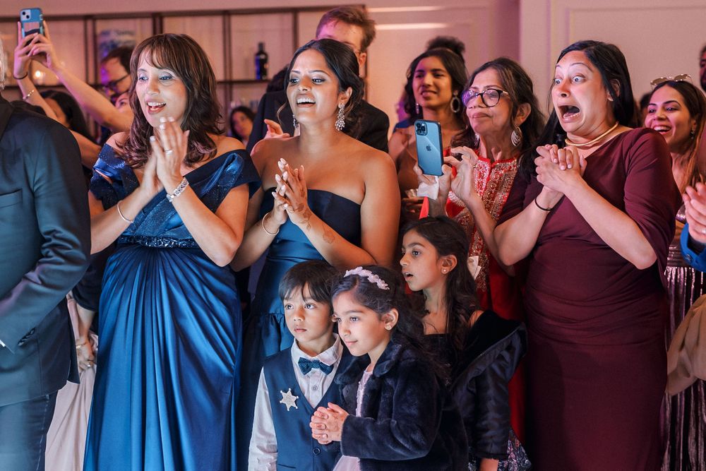 Guests reacting with joy and emotion during cake cutting at luxury Indian wedding in Portugal
