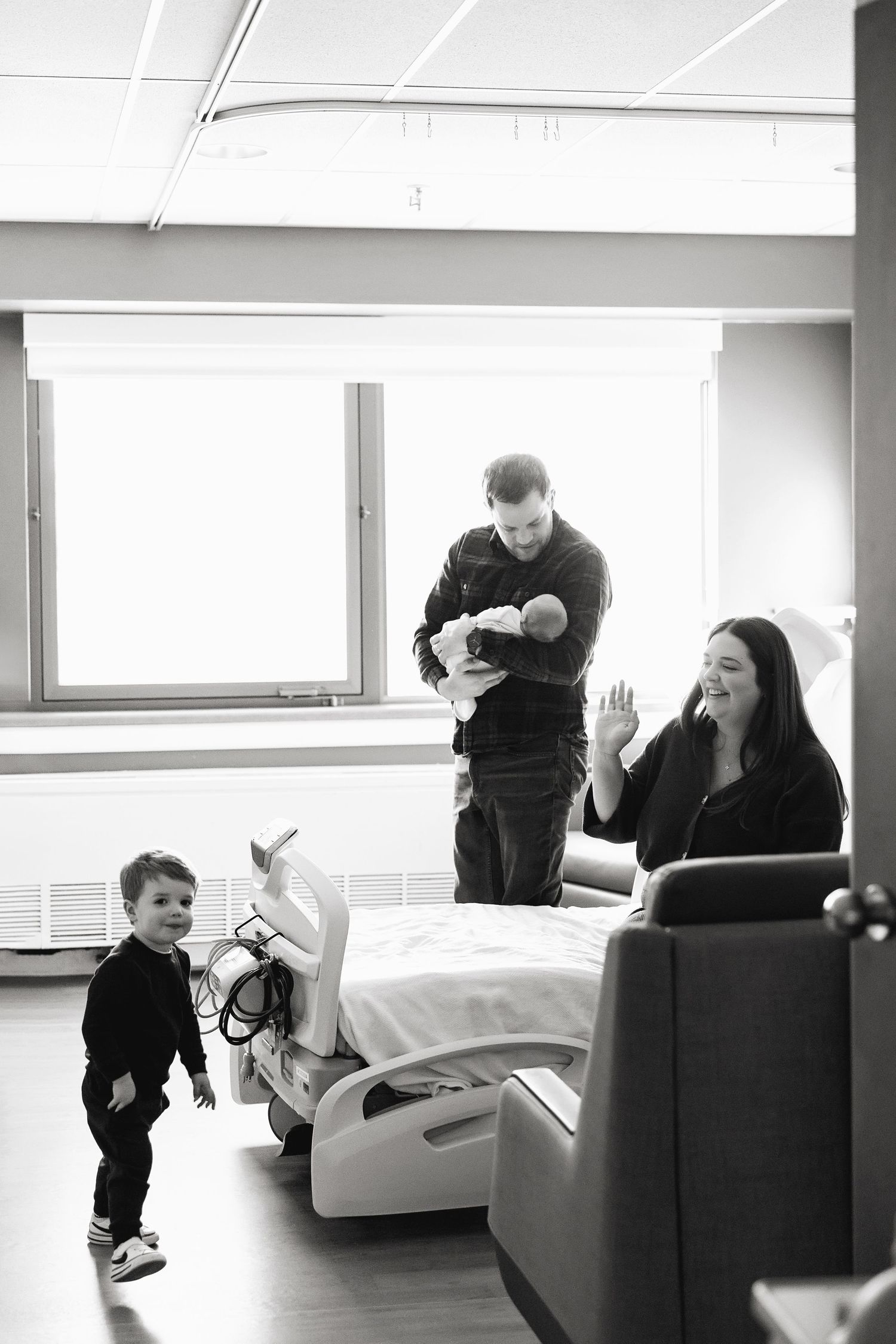 Black and white sequence showing people interacting on a couch in a minimalist interior setting.