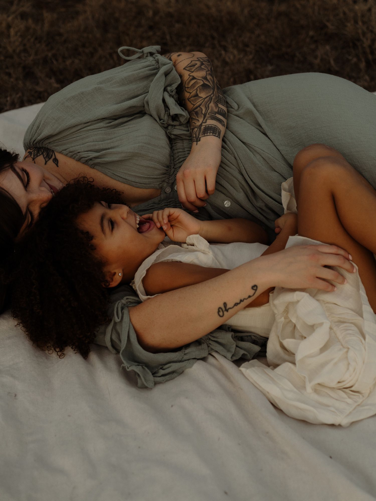 A person sleeping peacefully in bed wearing a gray shirt and white bedding.