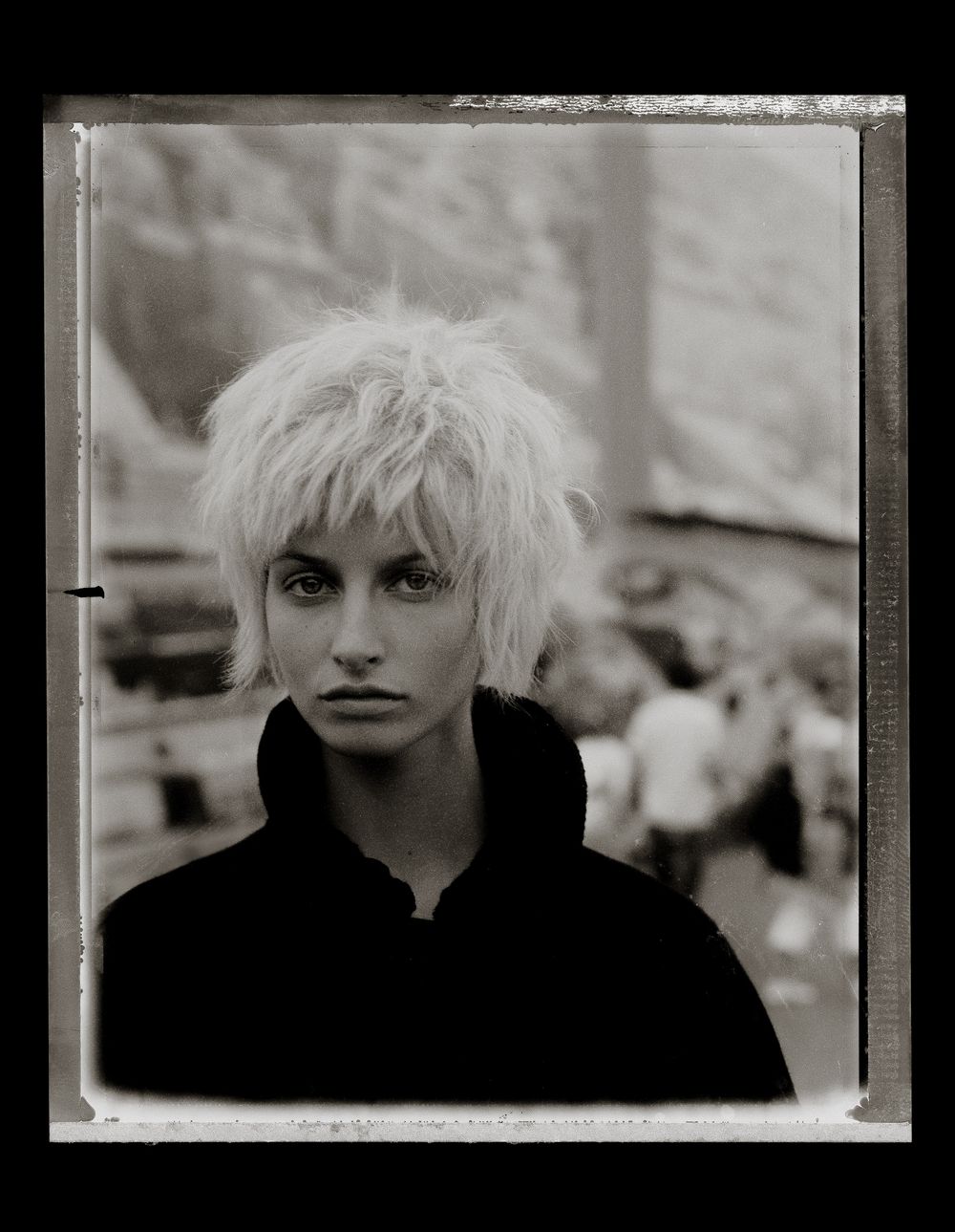 Black and white artistic portrait series showing a person with platinum blonde hair against dark backgrounds.