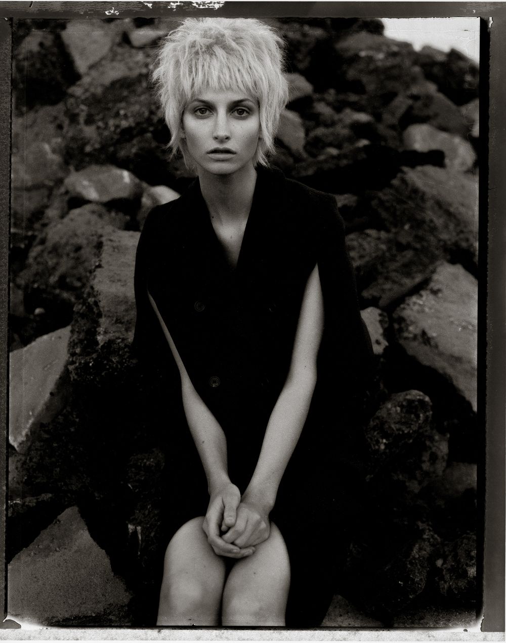 A series of black and white portrait photographs showing a figure in dark clothing against a moody background.